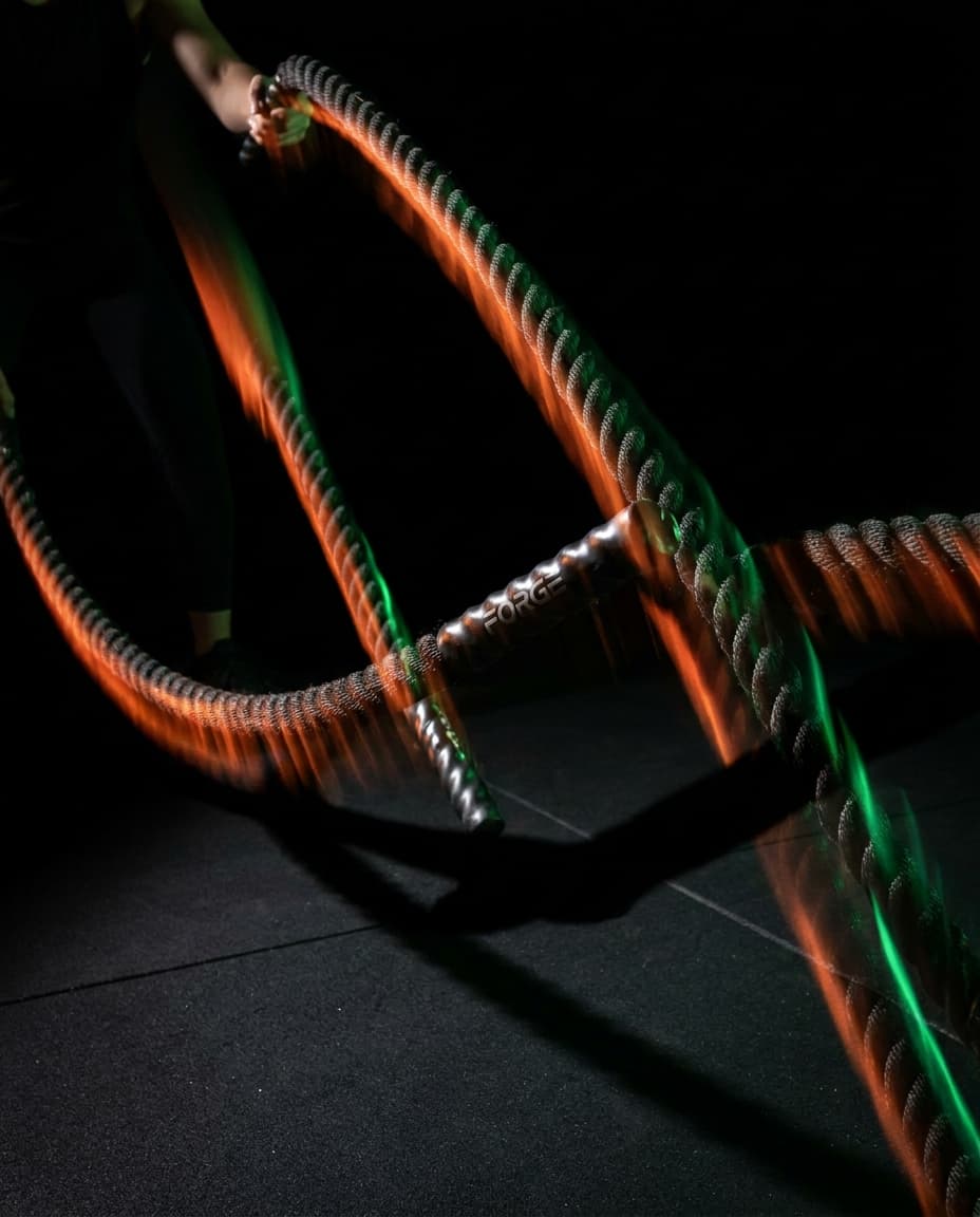 Battle ropes mid-swing with strong diagonal motion.
