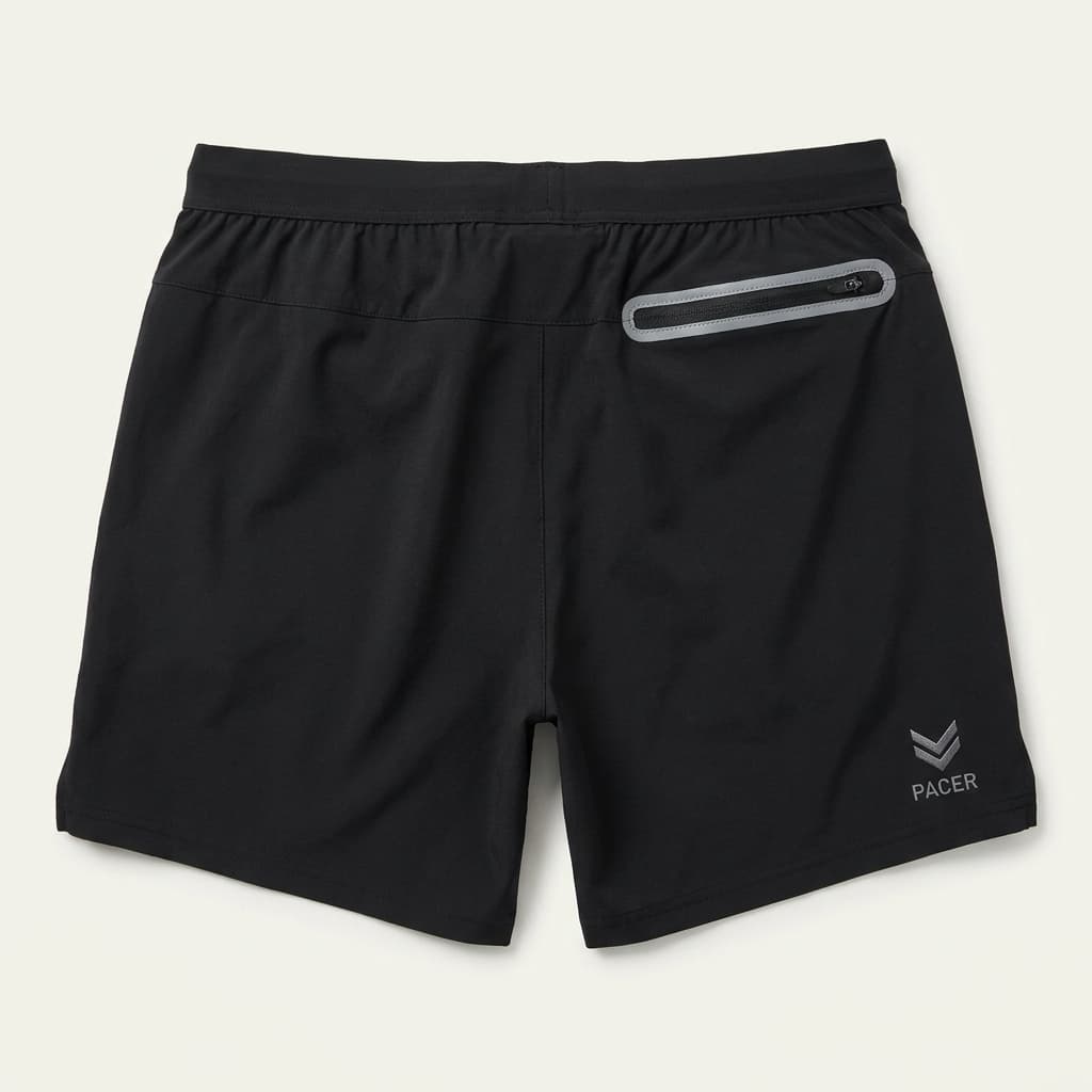 Pacer tempo running shorts in black on off-white background, technical pocket detail visible.